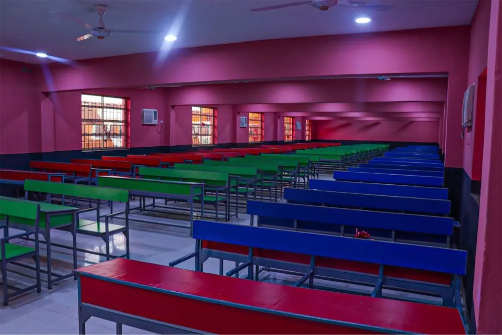 A tiered lecture hall with rows of coloured benches
